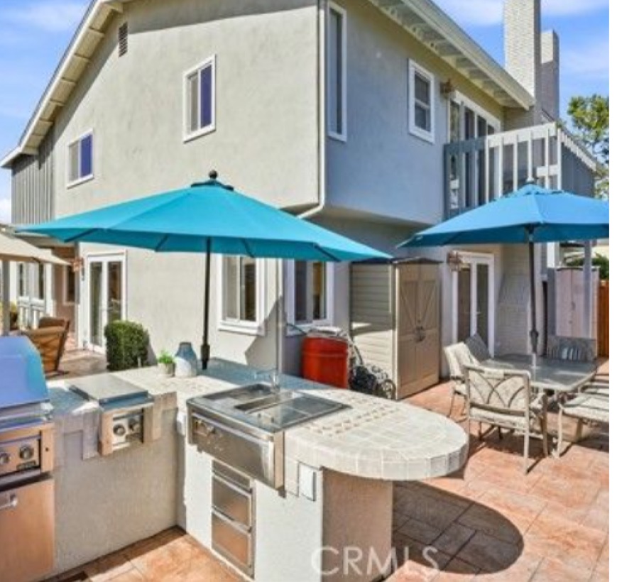 Private backyard at 8322 Padrino with built-in barbecue island and umbrella-shaded patio