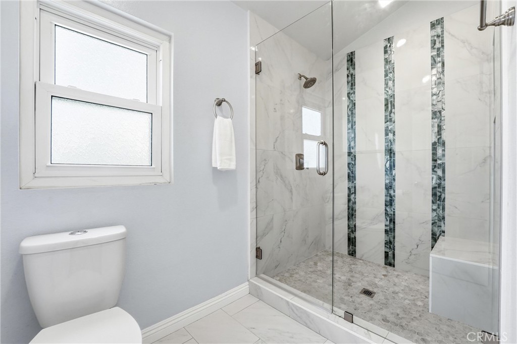 Remodeled primary bathroom at 8322 Padrino with oversized walk-in glass shower